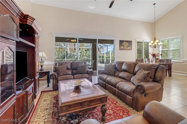 tiled living room with high vaulted ceiling, ceiling fan with notable chandelier, and plenty of natural light