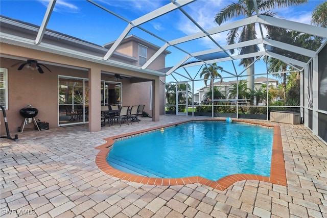 view of swimming pool featuring glass enclosure, a grill, ceiling fan, and a patio area