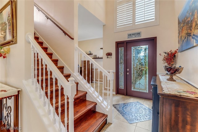 tiled entryway featuring a high ceiling