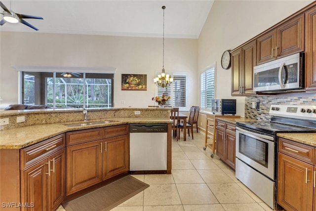 kitchen featuring stainless steel appliances, a healthy amount of sunlight, sink, and light stone counters