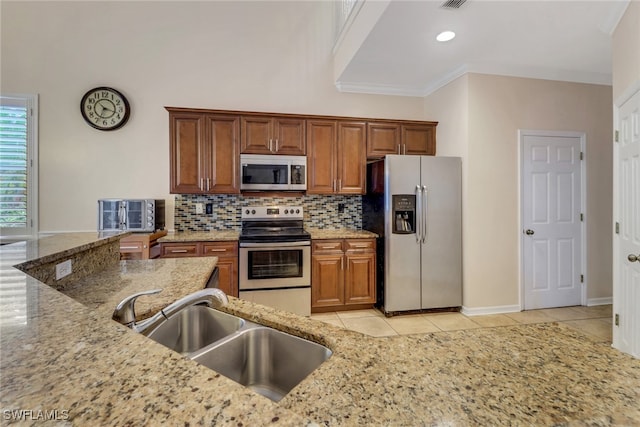 kitchen featuring sink, light stone counters, appliances with stainless steel finishes, ornamental molding, and backsplash