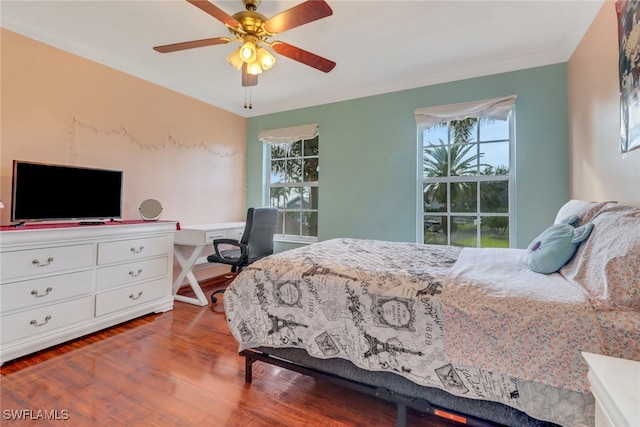 bedroom featuring wood-type flooring, built in desk, ceiling fan, and crown molding