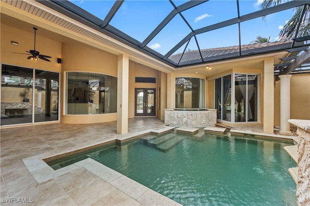 view of swimming pool featuring a patio area, glass enclosure, french doors, and ceiling fan