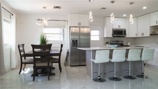 kitchen featuring white cabinets, a healthy amount of sunlight, and stainless steel appliances