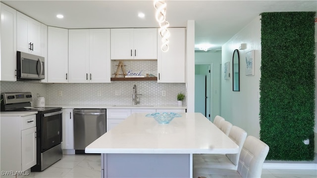 kitchen featuring sink, white cabinets, stainless steel appliances, and backsplash