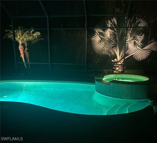 view of swimming pool featuring an in ground hot tub and glass enclosure