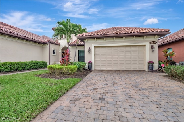 mediterranean / spanish-style house featuring a front yard and a garage