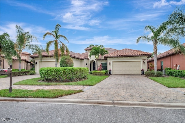 mediterranean / spanish home featuring a front lawn and a garage