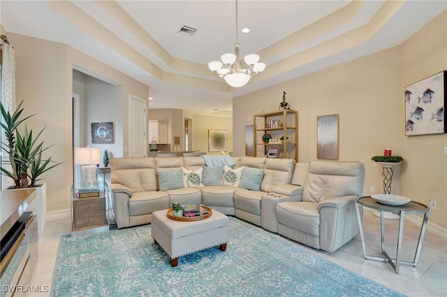 tiled living room featuring a notable chandelier and a raised ceiling