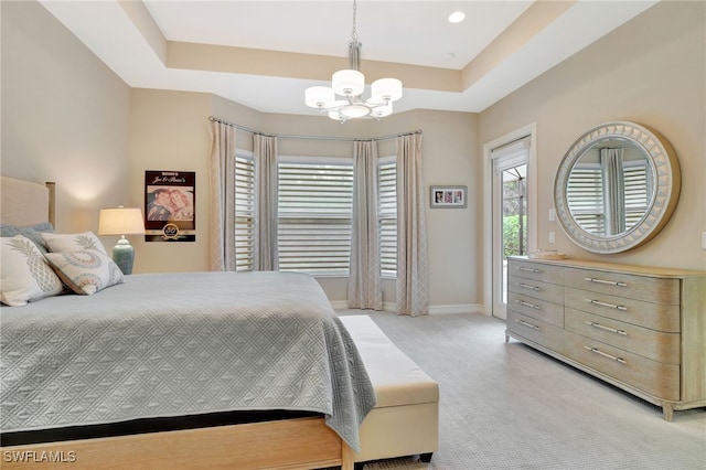 bedroom featuring a raised ceiling, a chandelier, and light colored carpet