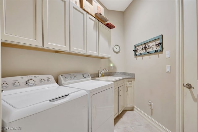 laundry area with cabinets, washer and dryer, sink, and light tile patterned floors