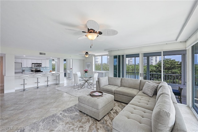 living room featuring ceiling fan and plenty of natural light