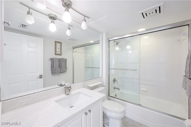 full bathroom with toilet, vanity, and bath / shower combo with glass door