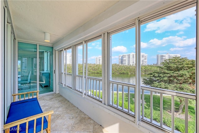 sunroom / solarium featuring a water view