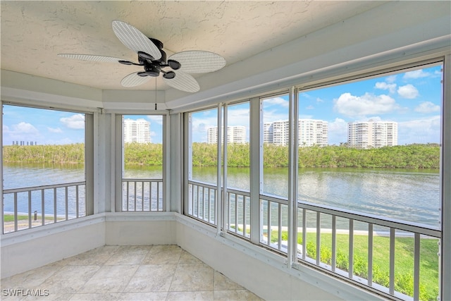 unfurnished sunroom with a water view and ceiling fan