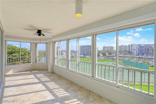 unfurnished sunroom with ceiling fan