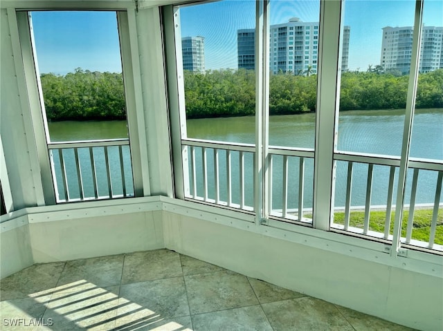 unfurnished sunroom featuring a water view