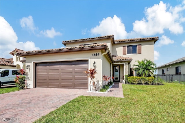 mediterranean / spanish house featuring a front yard and a garage