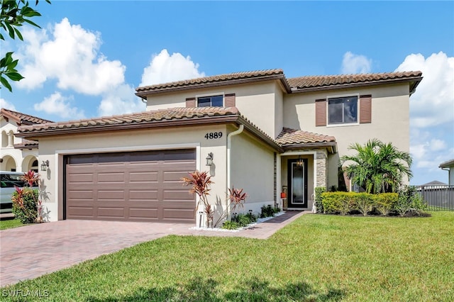 mediterranean / spanish-style home featuring a front lawn and a garage