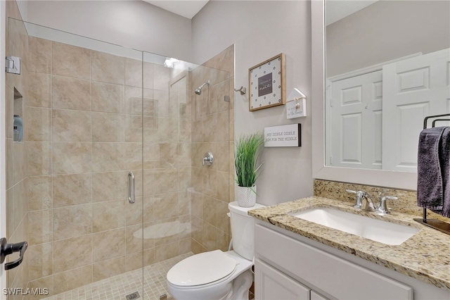 bathroom featuring vanity, toilet, and walk in shower