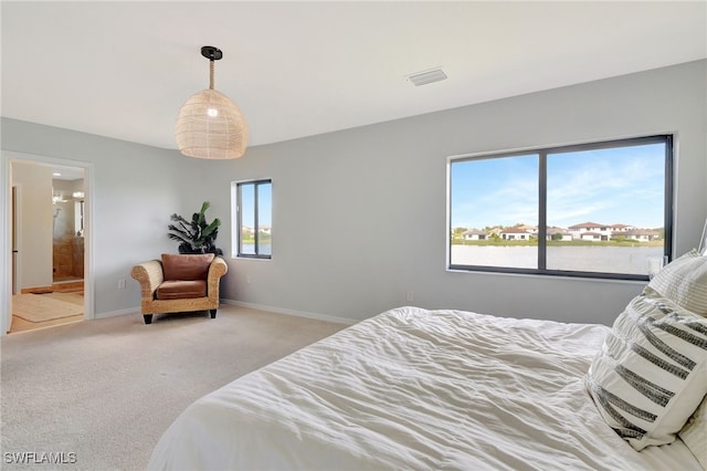 bedroom featuring connected bathroom and carpet