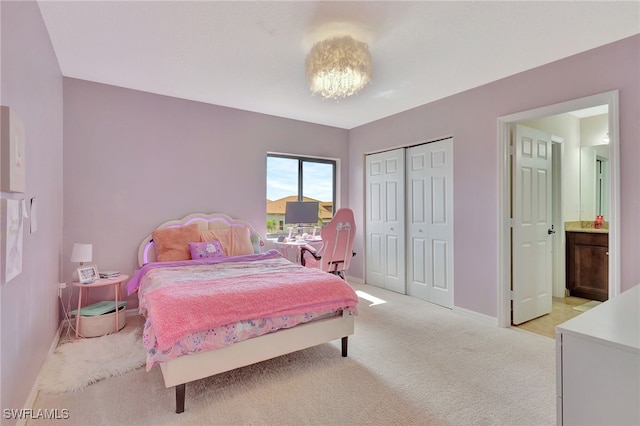 bedroom featuring ensuite bath and light colored carpet