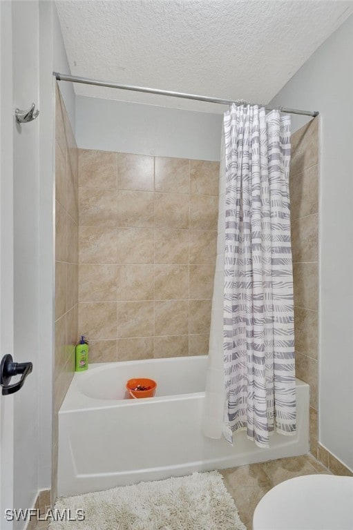 bathroom featuring toilet, a textured ceiling, shower / bathtub combination with curtain, and tile patterned flooring