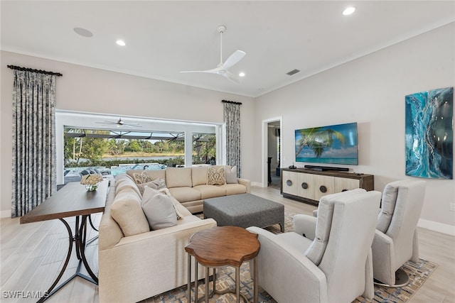 living room featuring light hardwood / wood-style floors, ornamental molding, and ceiling fan