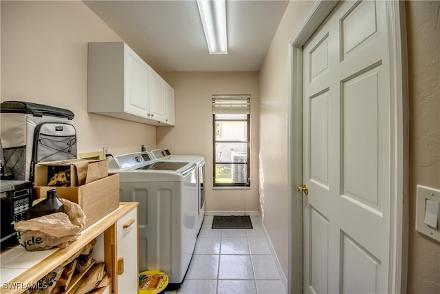 clothes washing area featuring cabinets, independent washer and dryer, and light tile patterned flooring