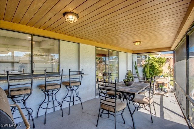 sunroom / solarium featuring wood ceiling and a healthy amount of sunlight