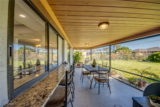 sunroom / solarium featuring wooden ceiling and plenty of natural light