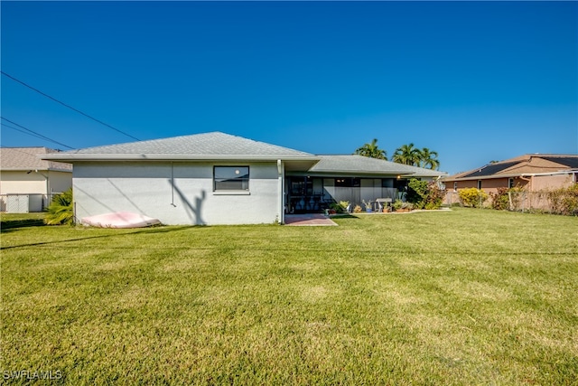 back of property with a yard and a patio area