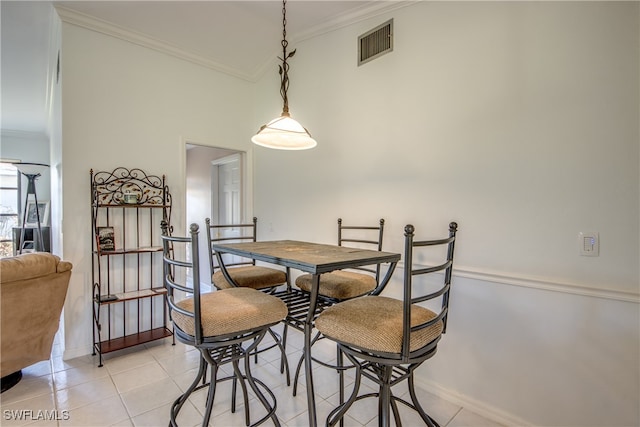 dining area featuring crown molding and light tile patterned floors