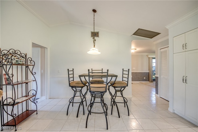 tiled dining room featuring crown molding and vaulted ceiling