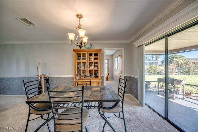 carpeted dining room featuring crown molding, a notable chandelier, and a healthy amount of sunlight