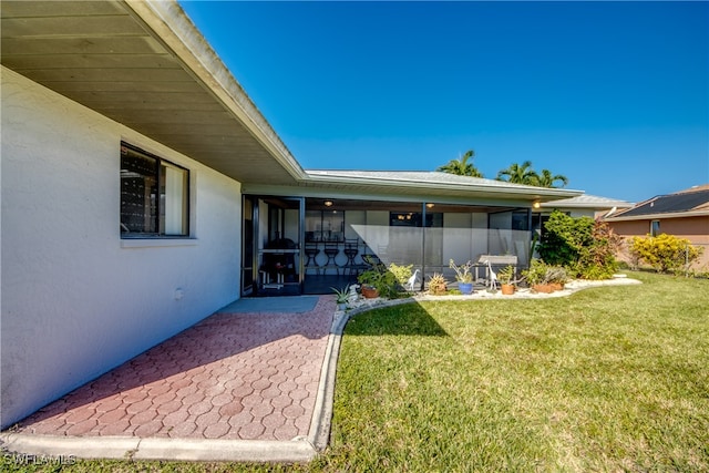 entrance to property with a patio area and a lawn