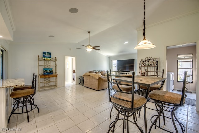 tiled dining room featuring lofted ceiling, ornamental molding, and ceiling fan