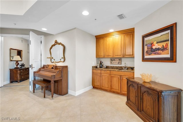 kitchen with stone counters and sink