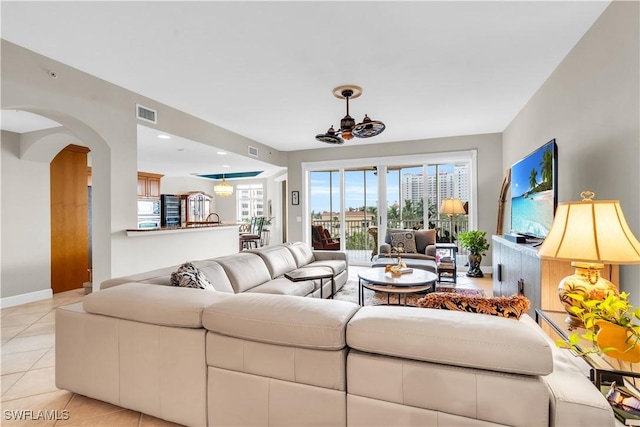 living room featuring ceiling fan and light tile patterned floors