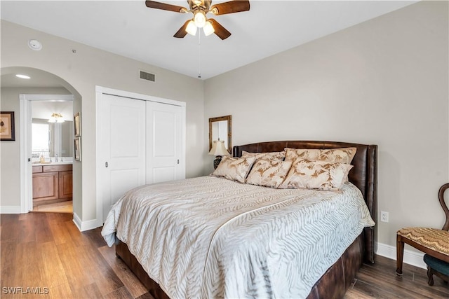 bedroom with ensuite bath, a closet, dark hardwood / wood-style floors, and ceiling fan