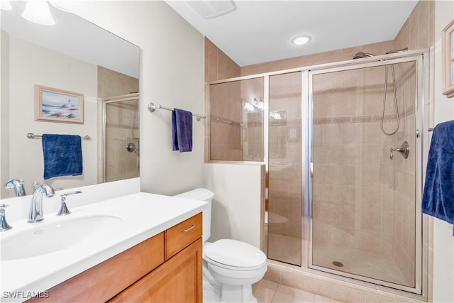 bathroom featuring toilet, vanity, tile patterned floors, and walk in shower