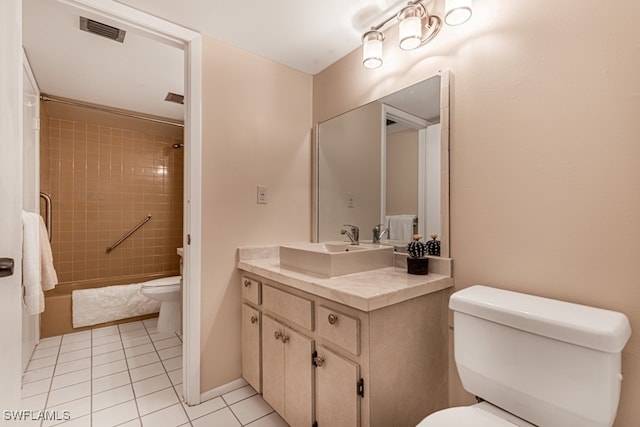 bathroom featuring toilet, vanity, a tile shower, and tile patterned flooring