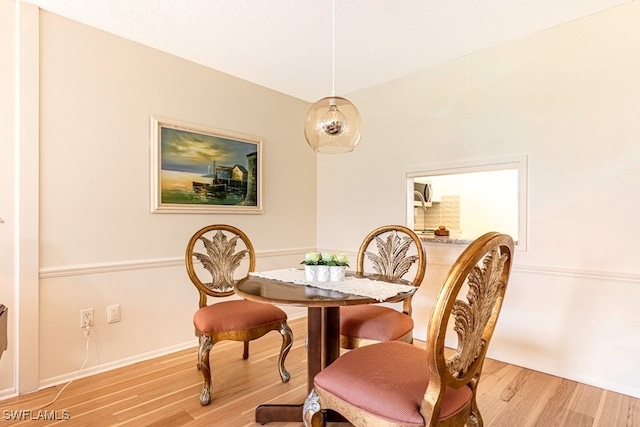 dining room featuring light hardwood / wood-style flooring and a textured ceiling