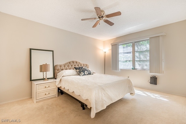 bedroom with light carpet, a textured ceiling, and ceiling fan