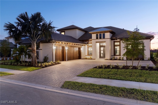 view of front of property featuring stucco siding, driveway, and a garage