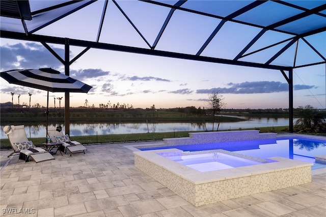 pool featuring a patio, glass enclosure, a water view, and an in ground hot tub