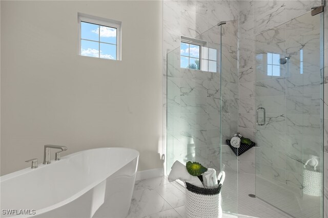 full bath with a shower stall, a freestanding tub, a healthy amount of sunlight, and marble finish floor
