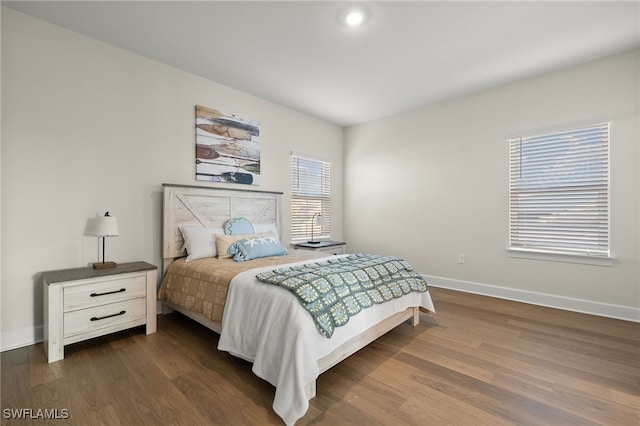 bedroom with dark wood finished floors and baseboards