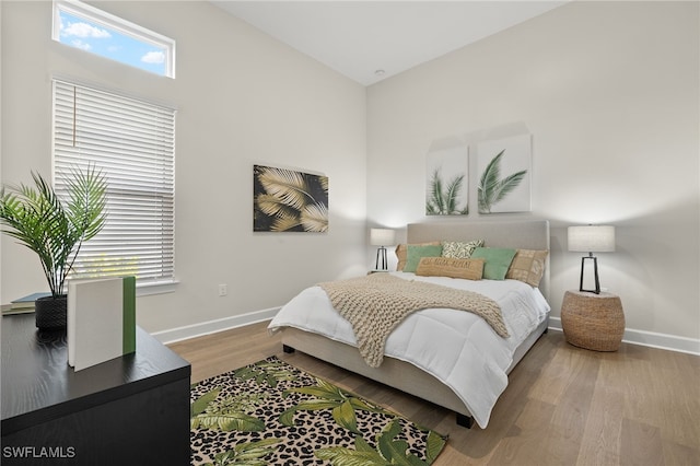bedroom featuring wood finished floors and baseboards
