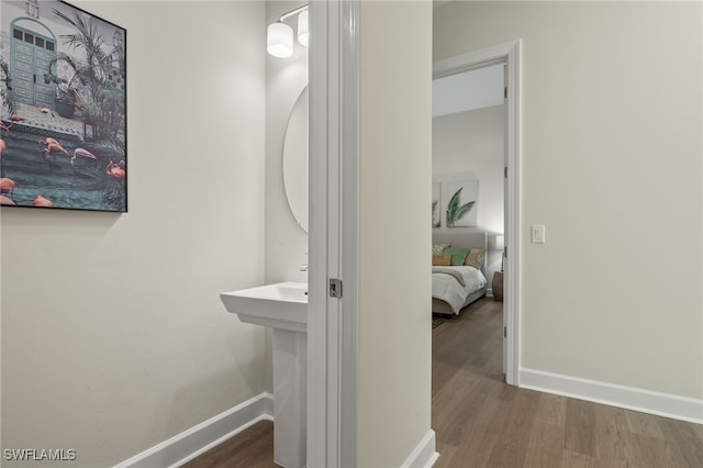 corridor featuring wood finished floors and baseboards